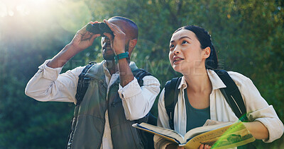 Buy stock photo Nature, book and couple with binocular for hiking, sightseeing adventure and bird watching together. Interracial relationship, man and woman with trekking for travel vacation, location and bonding