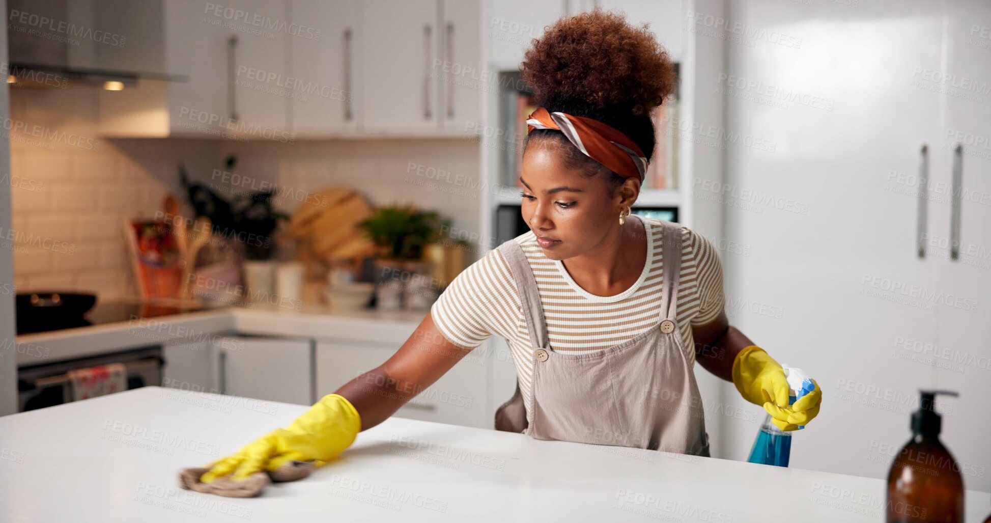 Buy stock photo Woman, cloth and wipe on kitchen counter for hygiene with spray, gloves or chemical for shine in home. African person, cleaning and bottle for dust, dirt or bacteria with sanitation liquid in house
