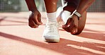 Person, hands and tying shoes with laces for sport, fitness or outdoor exercise on turf or court. Closeup, athlete or runner getting ready with tie or sneakers for game, match start or workout prep