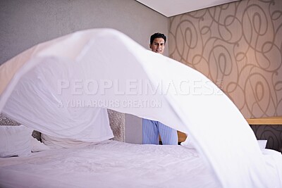 Buy stock photo Man, morning and making bed in home for hygiene and routine of change fresh linen on weekend. Tidy, bedroom or modern guy with happy for housekeeping, healthy or spring cleaning on vacation in house