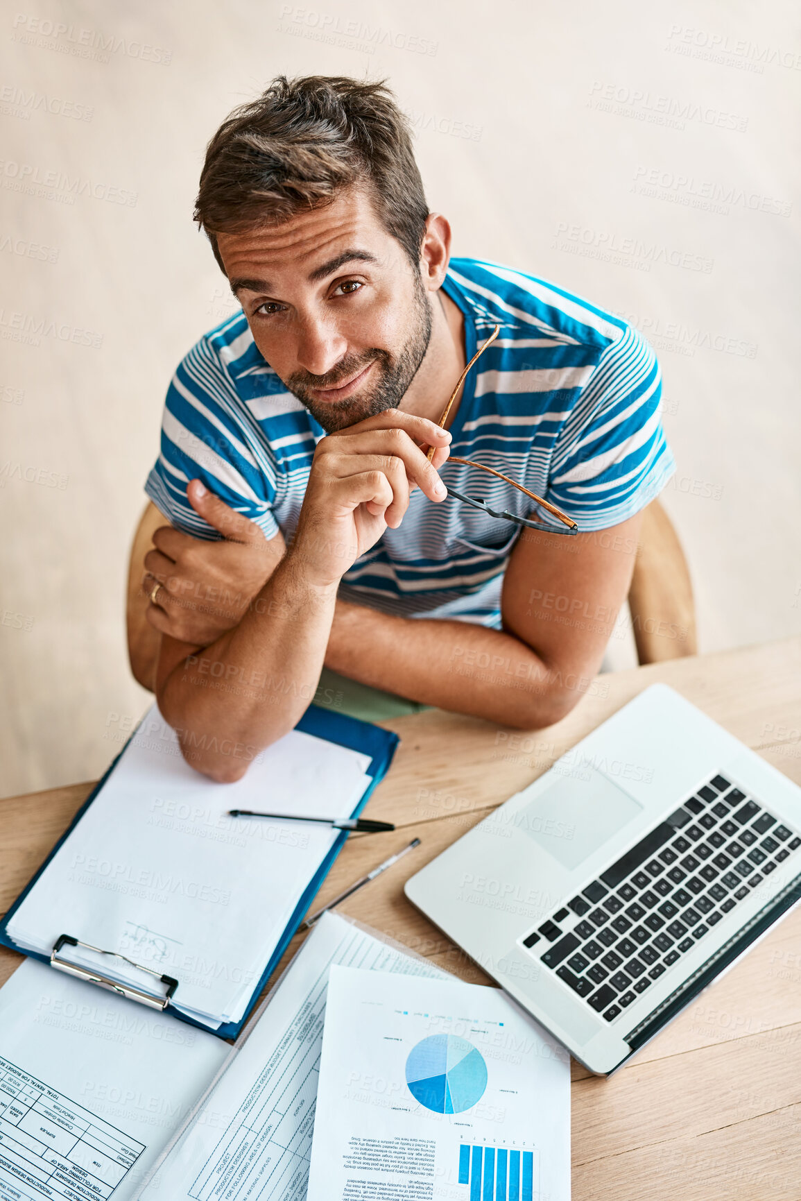 Buy stock photo Man, portrait and top view with laptop in home office for work as freelance web or graphic designer. Person, documents and data report for performance metrics, budget tracking and website progress.