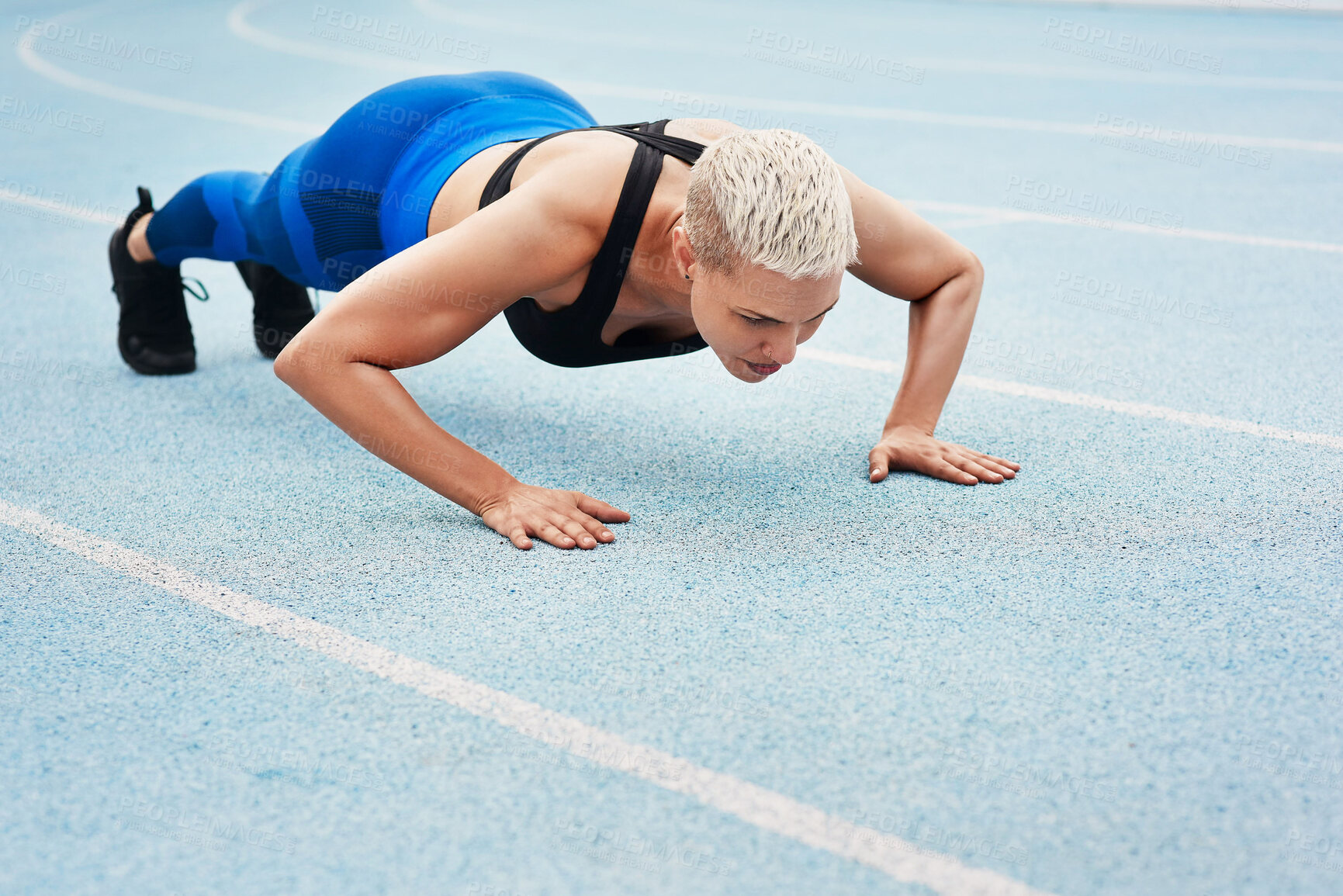 Buy stock photo Woman, pushups and track for sports, exercise and warm up in stadium or field for fitness. Female athlete, training and cardio in outdoor for wellness, performance and strong in body or strength