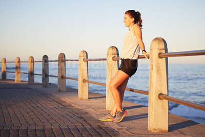 Buy stock photo Fitness, break and thinking by woman by ocean, nature and cardio for health. Music, audio and podcast for wellness and marathon endurance sport training, female athlete and relax for workout