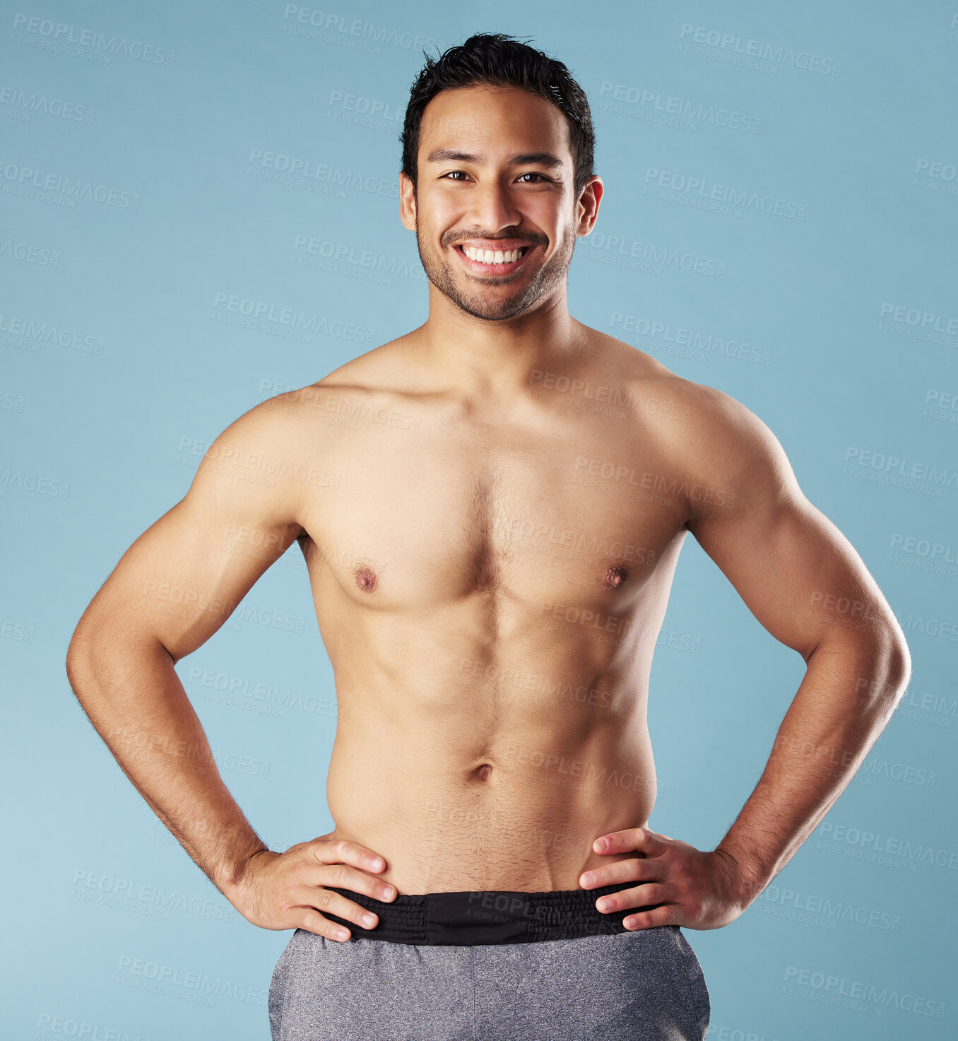 Buy stock photo Man, fitness and portrait with muscle in studio, pride or excited for body transformation by blue background. Asian person, bodybuilder and smile for abs, growth or shirtless for wellness in Malaysia