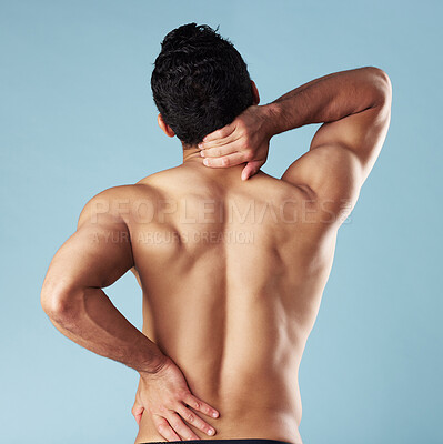 Buy stock photo Back pain, shirtless and man in studio, strain and muscle tension on blue background. Person, bruise and model with fitness, inflammation and pressure with burnout, injury and sports athlete