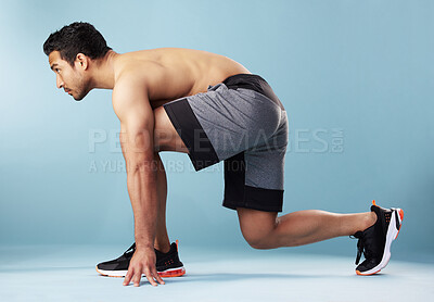 Buy stock photo Fitness, profile and race with man in studio for start of competition, marathon or sports event. Challenge, exercise and ready with shirtless runner on blue background for performance or training