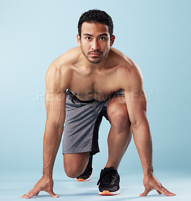 Buy stock photo Fitness, portrait and race with man in studio for start of challenge, competition or sports event. Exercise, ready and running with shirtless athlete on blue background for performance or training