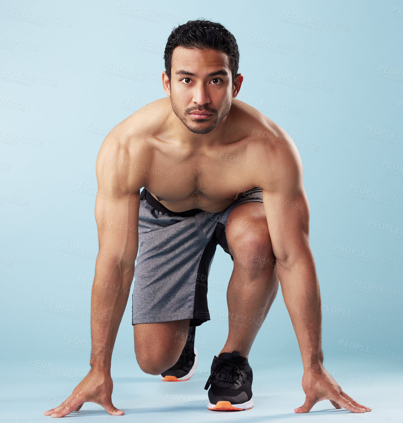 Buy stock photo Fitness, portrait and race with man in studio for start of challenge, competition or sports event. Exercise, ready and running with shirtless athlete on blue background for performance or training