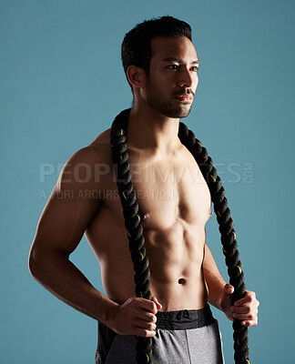 Buy stock photo Fitness, rope and thinking with man in studio for exercise, training or workout routine. Future, health and shirtless with confident model on blue background for challenge, performance or power