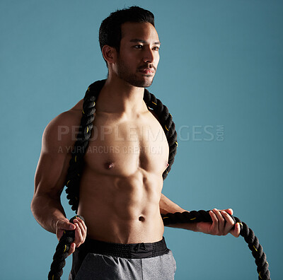 Buy stock photo Fitness, future and ropes with man in studio for exercise, training or workout routine. Idea, planning and thinking with shirtless model on blue background for challenge, performance or power