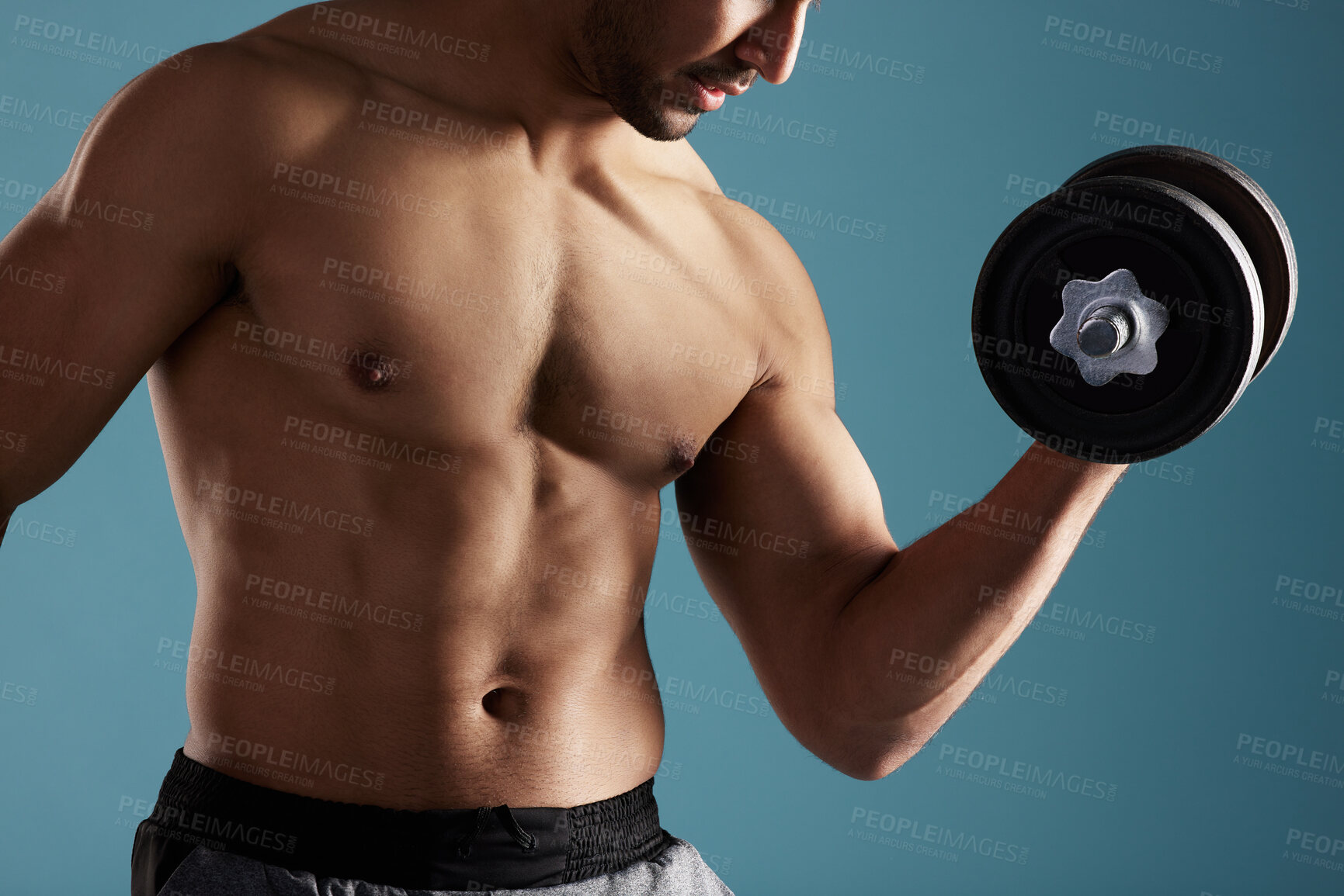 Buy stock photo Fitness, hands and man training with dumbbell for workout, exercise and body wellness. Muscle, shirtless bodybuilder and weightlifting for bicep strength, power and energy on blue studio background