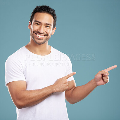 Buy stock photo Portrait, man and smile pointing in studio of presentation, announcement news and information. Happy, male person and hand gesture for coming soon, sign up timeline and opportunity on blue background