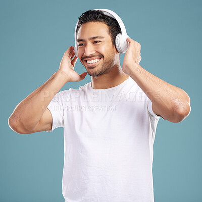 Buy stock photo Studio, man and happy with headphones for music, podcast and satisfied with playlist for motivation. Smile, male person and model for listening to audio, streaming sound and radio by blue background