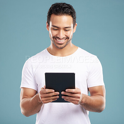 Buy stock photo Studio, man and smile with tablet for social media, reading news and connection for communication. Happiness, male person and online with digital for post comment, blog website and blue background