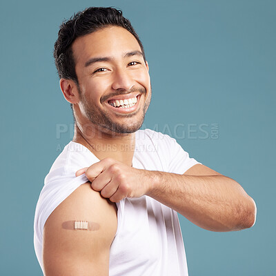 Buy stock photo Studio, happy man and portrait with plaster for vaccine, injection wound and safety for Influenza. Blue background, male person and smile with bandage for healthcare, medicine and treatment for virus