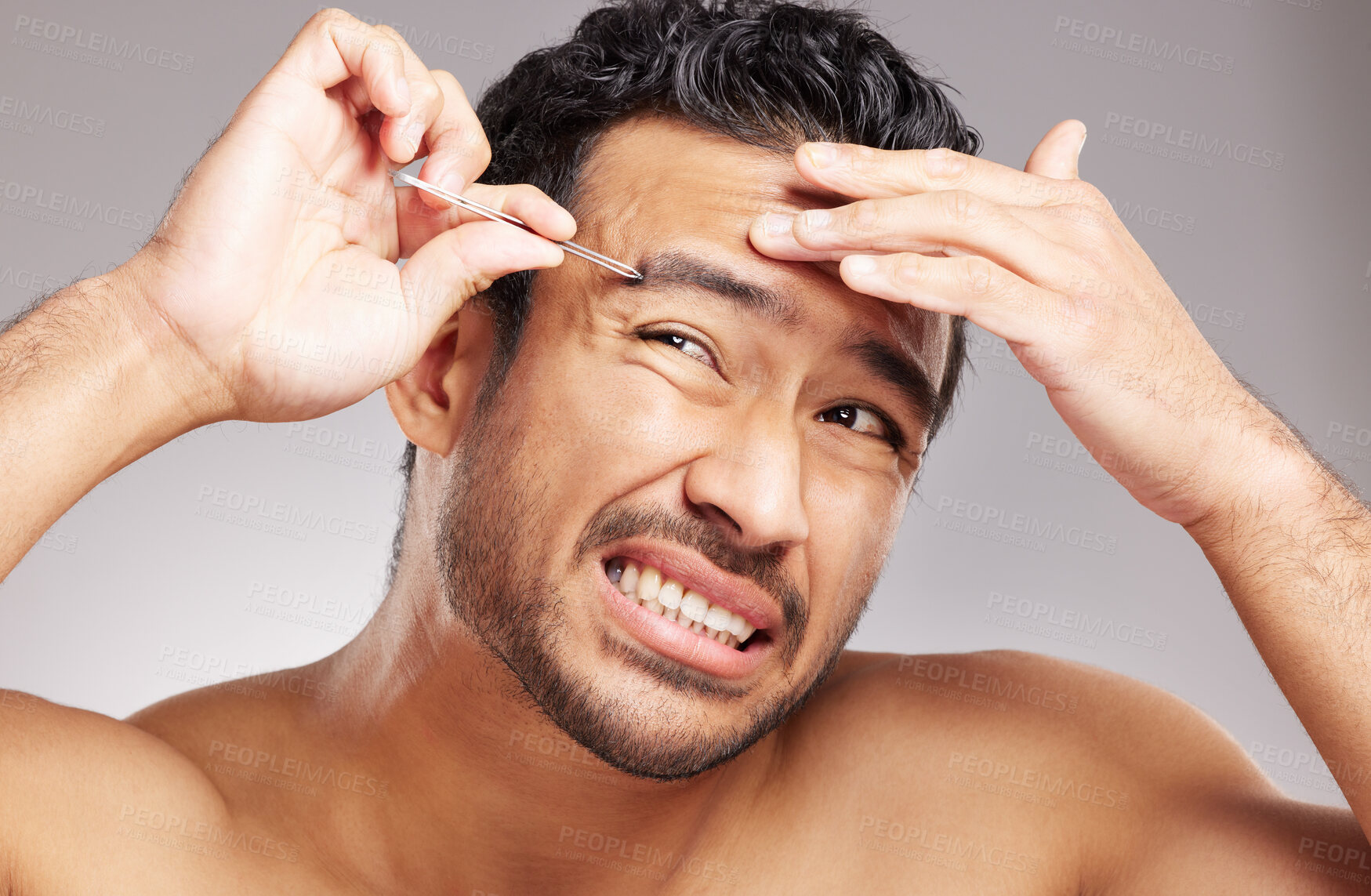 Buy stock photo Man, pain and tweezers by face in studio for eyebrow shape, grooming routine and epilation. Topless, person and cosmetic tool for hair removal, hygiene maintenance and cleanliness on gray background