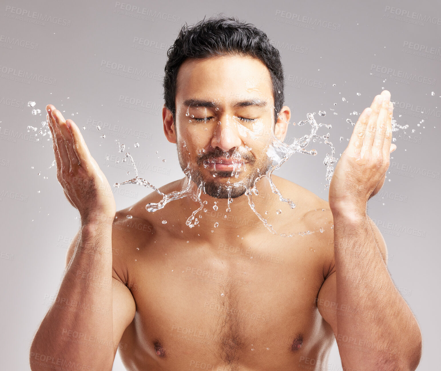 Buy stock photo Man, water splash and cleaning face in studio for skincare, hygiene or healthy skin. Person, washing or grooming for morning routine, self care or bacteria removal with cleanliness on gray background
