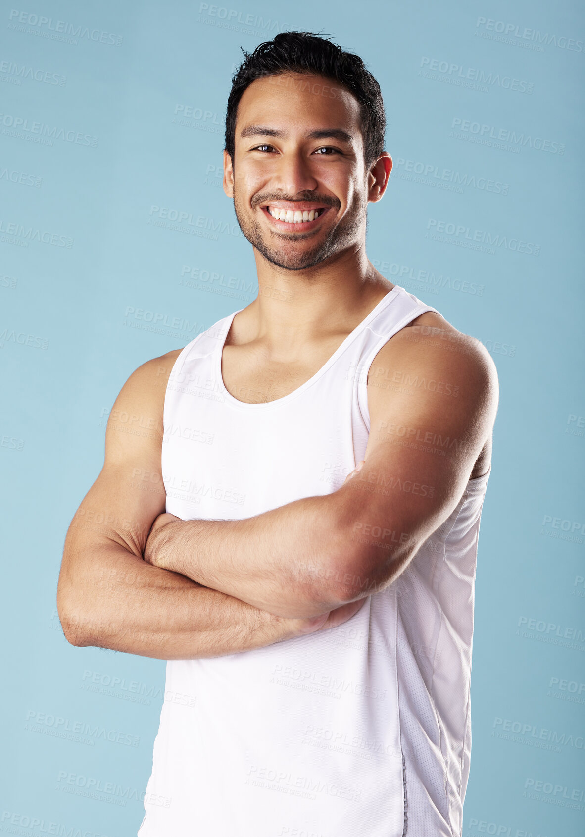 Buy stock photo Arms crossed, fitness and portrait of man in studio for exercise, training or workout routine. Health, tank top and smile with confident model on blue background for challenge, sports or power