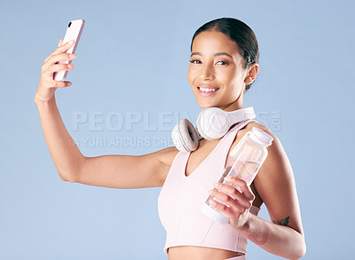 Buy stock photo Fitness, woman and portrait with selfie in studio, wellness and profile picture for social media. Smile, female person and model with photography for exercise memory, water bottle and blue background