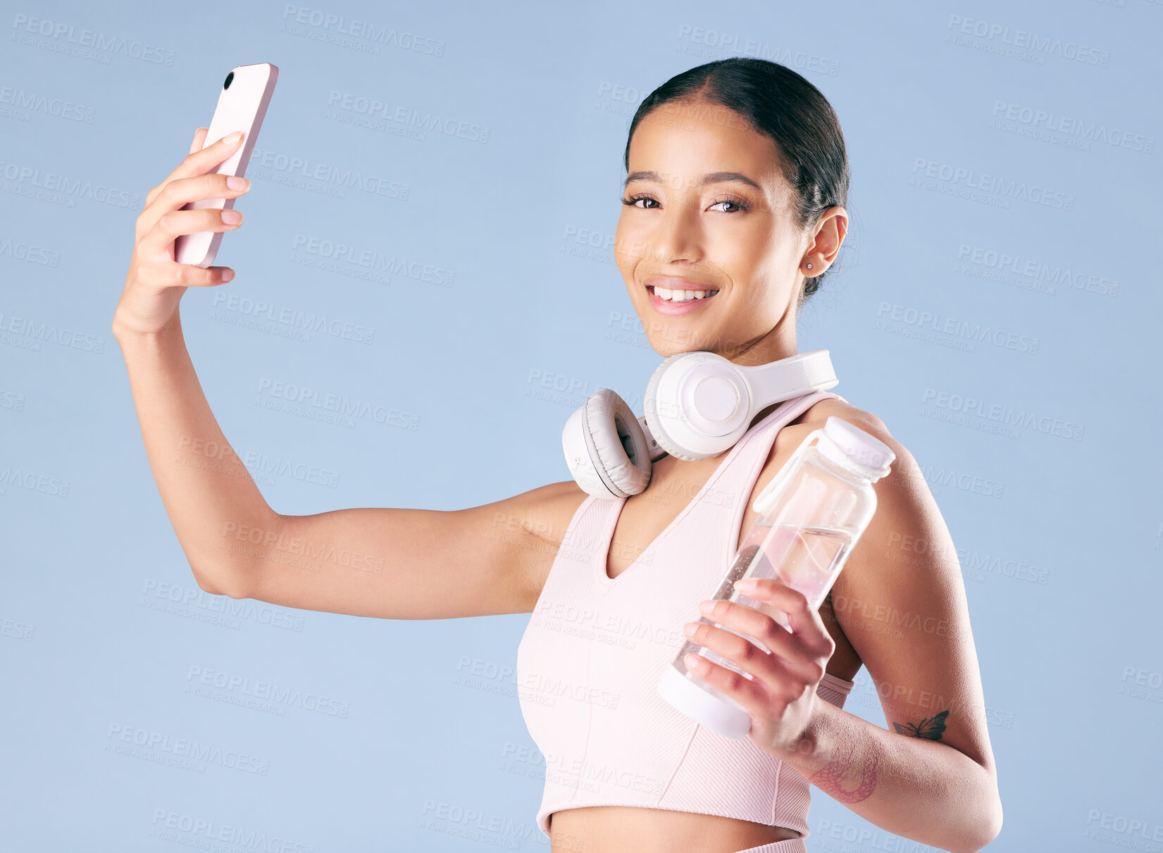 Buy stock photo Fitness, woman and portrait with selfie in studio, wellness and profile picture for social media. Smile, female person and model with photography for exercise memory, water bottle and blue background
