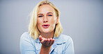 Blowing, kiss and portrait of woman on gray background with reaction for flirting, romance and pride. Happy, hand gesture and isolated person with emoji for love, dating and valentines day in studio