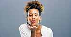 Woman, portrait and blowing kiss in studio for affection, romance and flirting on gray background. Mockup space, person and kindness gesture for gratitude, thank you and attraction with smile or care