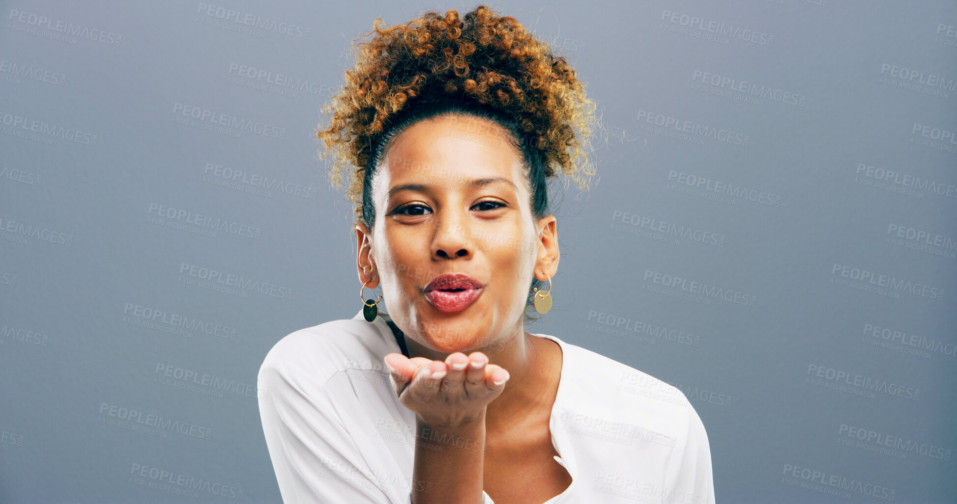 Buy stock photo Woman, portrait and blowing kiss in studio for affection, romance and flirting on gray background. Mockup space, person and kindness gesture for gratitude, thank you and attraction with smile or care