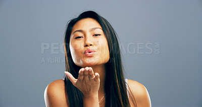Buy stock photo Blowing kiss, studio and portrait of Asian woman with reaction for flirting, romance and affection. Happy, hand gesture and person with emoji for love, dating and mockup space on blue background