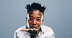 Black man, portrait and blowing with kiss for affection, love or romance on a blue studio background. Male person, face or nigerian model with hand or romantic gesture for distant compassion on space
