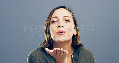 Buy stock photo Woman, portrait and blowing with kiss for love, romance or affection on a gray studio background. Female person, face or model with hand, lips or romantic gesture for distant compassion on space