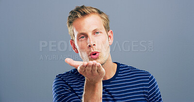 Buy stock photo Blow kiss, studio and portrait of man with reaction for flirting, romance and affection on blue background. Space, hand gesture and isolated person with emoji for love, dating and valentines day