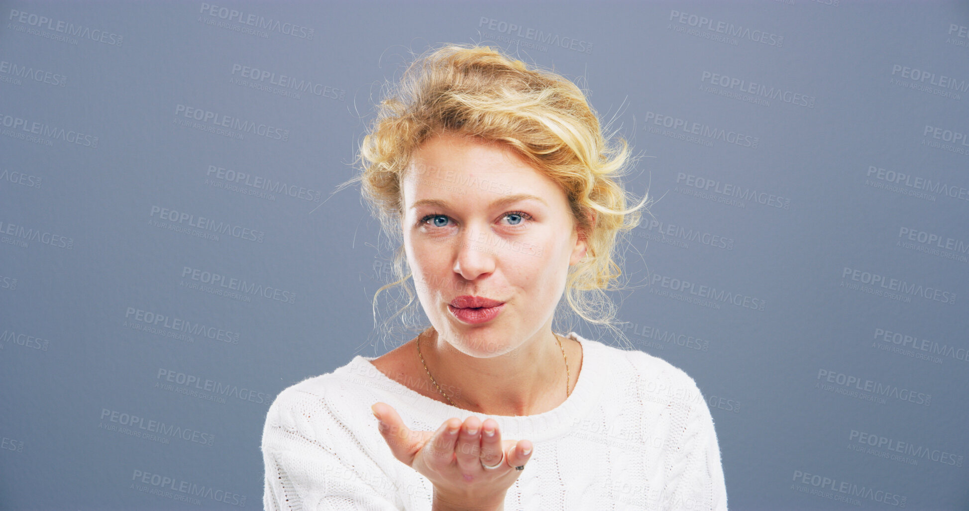 Buy stock photo Blowing kiss, happy and portrait of woman for flirting, romance and confident on blue background. Playful, hand gesture and isolated person with emoji for love, dating and mockup space in studio