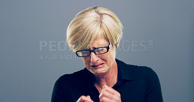 Buy stock photo Sad, mature woman and crying in studio with depression, mourning loss and emotional for memory. Female person, grief and tear with mental health crisis, bad news and ptsd challenge on gray background