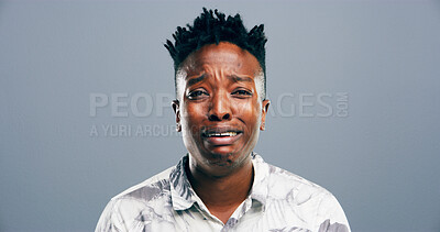Buy stock photo Crying, sad and portrait of black man in studio with grief, heartbreak and emotional on blue background. Tears, mourning and person with depression, upset and unhappy for breakup, bad news and pain