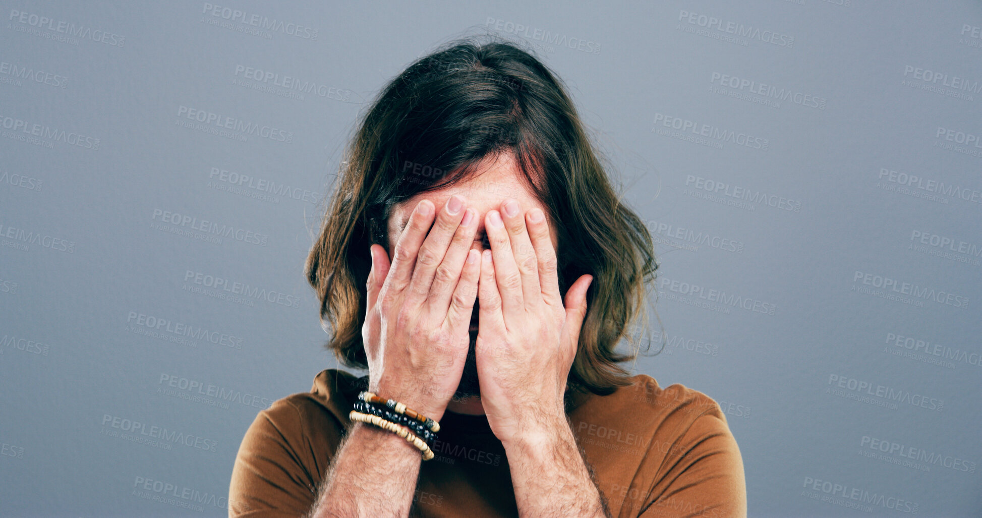 Buy stock photo Sad, crying and man with depression in studio for mourning loss, emotional memory and regret. Grief, person and cover face with space for mental health, bad news and ptsd trauma on gray background