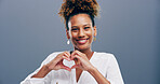 Happy, portrait and girl with heart hands in studio for appreciation, support and kindness. Mockup space, person and love gesture on gray background for care, gratitude and motivation sign with pride