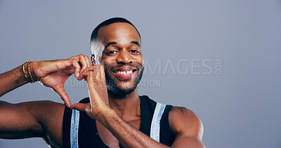 Buy stock photo Hands in heart, studio and portrait of black man with gesture for support, kindness and care. Happy, confident and person with emoji, sign and hope for thank you, charity and love on blue background