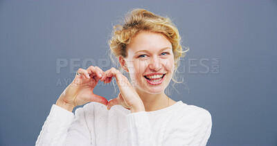 Buy stock photo Hands in heart, happy and portrait of woman with gesture for support, kindness and care. Studio space, confident and person with emoji, sign and hope for thank you, charity or love on blue background