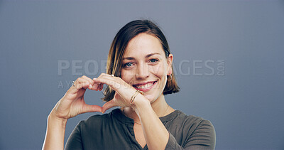 Buy stock photo Smile, portrait and woman with heart hands in studio for appreciation, kindness and support. Mockup, person and love gesture on gray background for affection, gratitude and motivation sign with pride