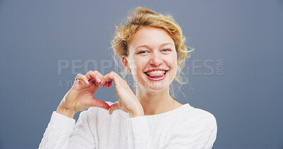 Buy stock photo Hands in heart, studio and portrait of woman with gesture for support, kindness and care. Happy, mockup space and person with emoji, sign and hope for thank you, charity and love on blue background