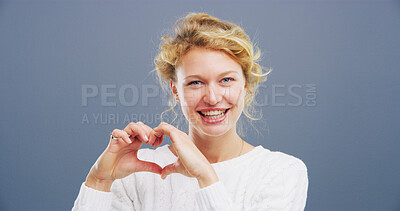 Buy stock photo Heart, studio and portrait of woman with hand gesture for support, kindness and care. Space, confident and happy person with emoji, sign and hope for thank you, charity and love on blue background