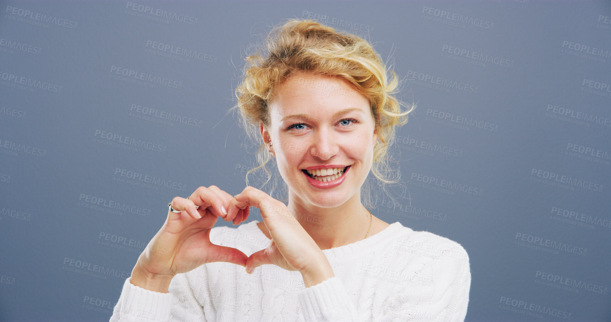 Buy stock photo Heart, studio and portrait of woman with hand gesture for support, kindness and care. Space, confident and happy person with emoji, sign and hope for thank you, charity and love on blue background