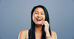 Asian woman, portrait and laughing in studio for joke, funny memory and comedy with mockup space. Model, female person and happiness with humor by blue background, satisfaction and emoji reaction