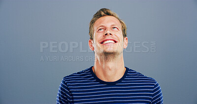 Buy stock photo Smile, space and thinking with man in studio for contemplation, memories or nostalgia. Idea, inspiration and mockup with happy model isolated on gray background for future, planning or vision