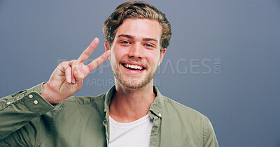Buy stock photo Man, peace sign and smile in studio portrait, v icon and space by gray background. Model, person and excited with symbol, happy or pride with emoji in trendy fashion, style or hand gesture in Germany