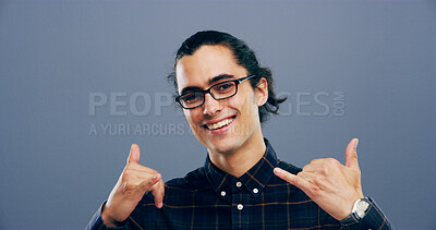 Buy stock photo Portrait, man and call me sign at studio, symbol or connection emoji with glasses on background. Hands, smile and person with hang loose, shaka gesture or communication to get in touch with contact