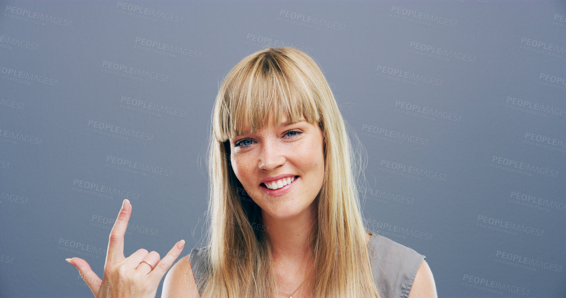 Buy stock photo Portrait, happy woman and rock hand gesture in studio for music, heavy metal and cool emoji for culture. Smile, devil horns and person with symbol, sign or punk isolated on background in Netherlands