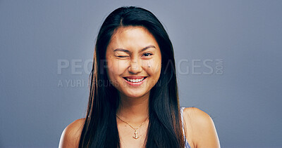 Buy stock photo Wink, happy and portrait of Asian woman in studio for secret, agreement and support gesture. Smile, feedback and thank you with female person on background for review, achievement and well done sign
