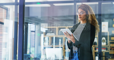 Buy stock photo Creative woman, browsing and research with tablet by window for company or project design at office. Female person, designer or employee with technology for schedule, planning or tasks at workplace