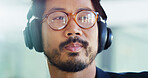 Thinking, headphones or man with glasses in office for technology, podcast playlist and brainstorming. Face, music and Asian developer with eyewear for clear vision, creative ideas and reflection